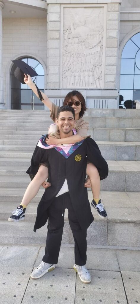 Homero is pictured in a graduation gown on the steps of Xiamen University. 